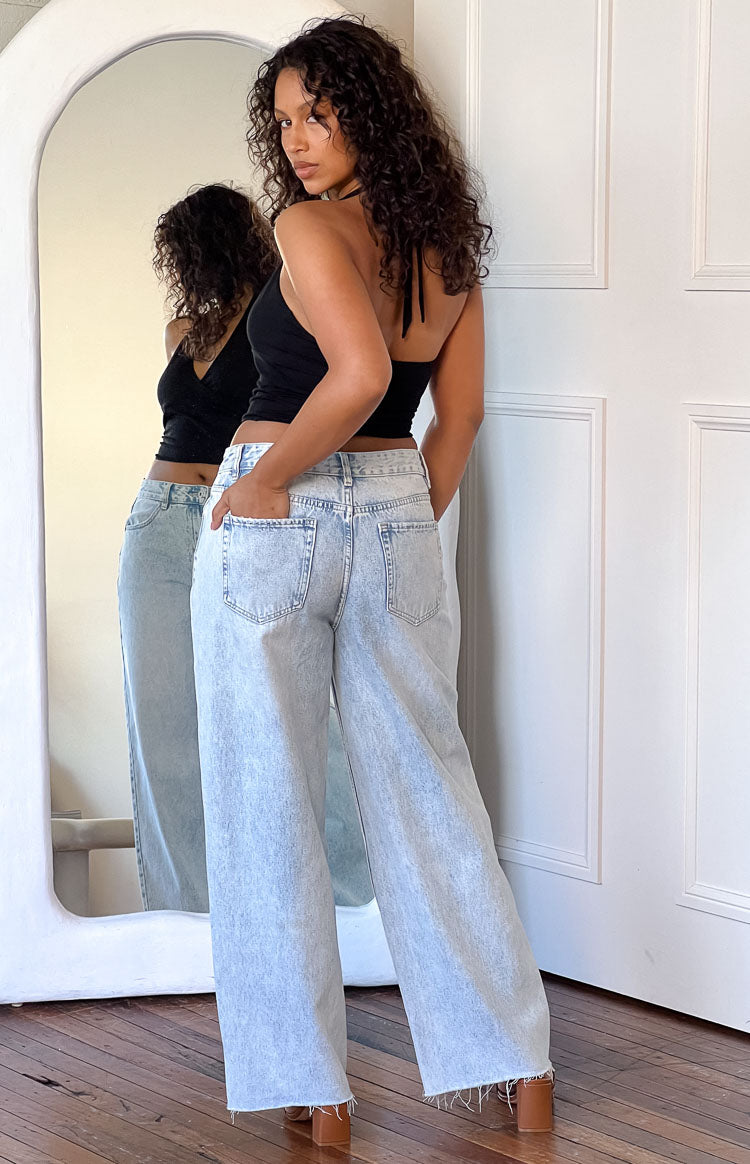 Donna con jeans boyfriend casual, vita media, gamba larga e orlo grezzo. Stile primavera estate.