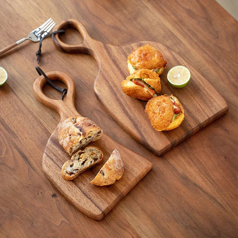 Due taglieri robusti in legno di noce, ideali per la cucina moderna, resistenti per tagliare e servire.