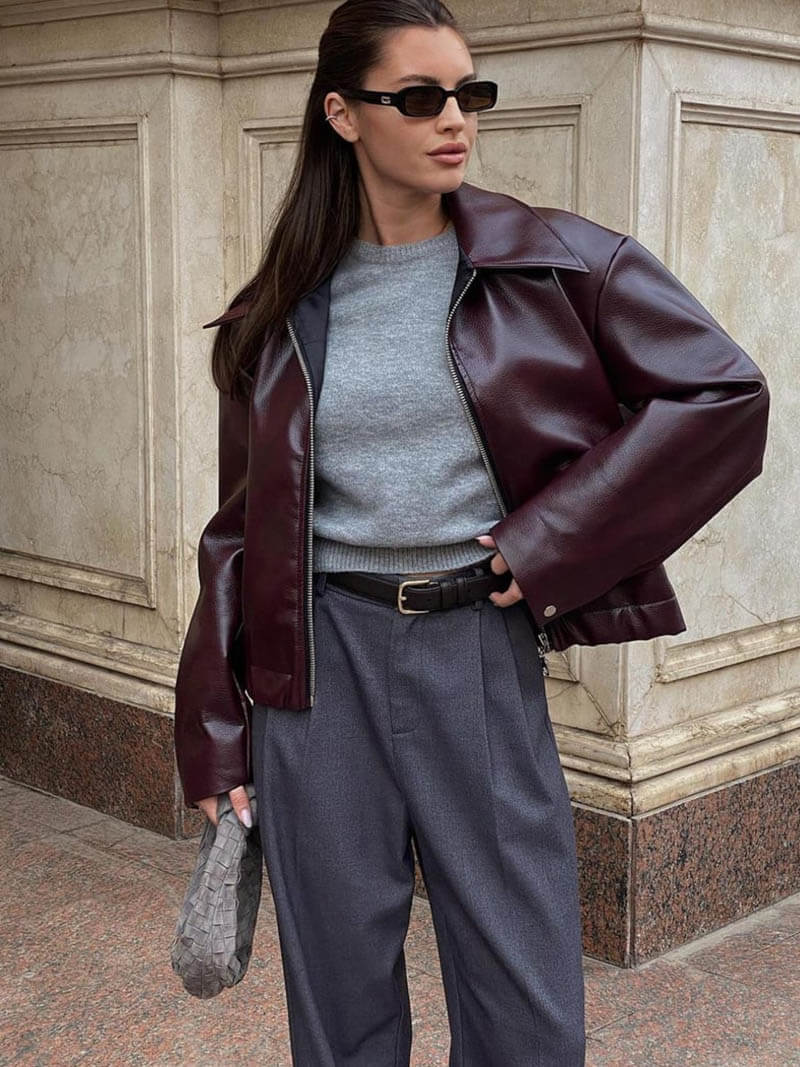 Dettaglio della giacca in pelle da donna, zip frontale e colletto classico. Abbigliamento elegante e moderno.