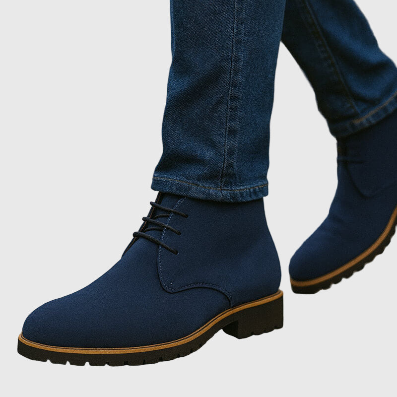 Primo piano di stivali uomo chukka in pelle scamosciata con lacci, un dettaglio moda per calzature uomo moderne.