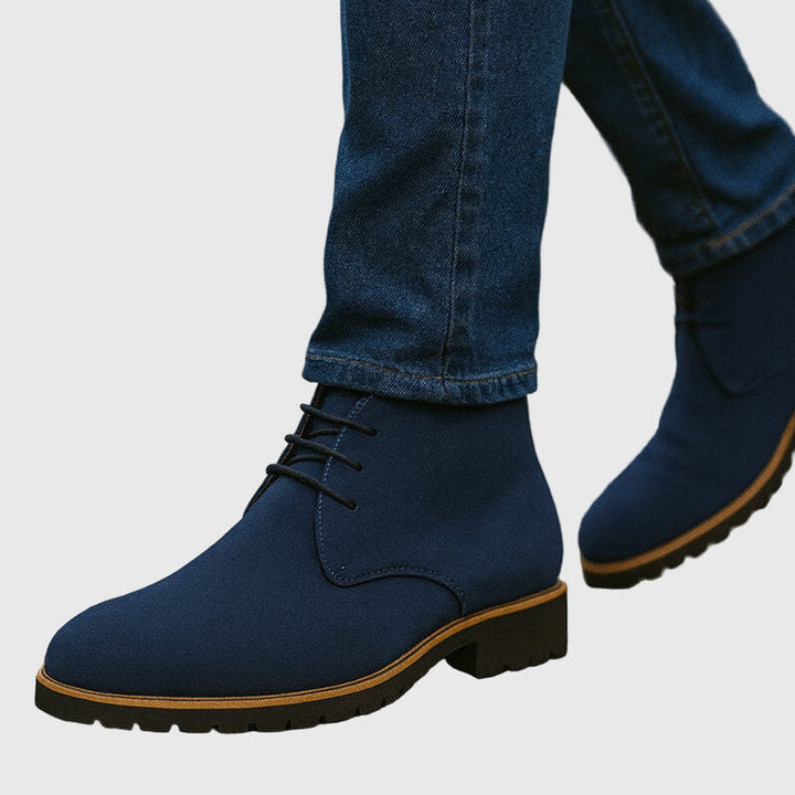 Primo piano di stivali uomo chukka in pelle scamosciata con lacci, un dettaglio moda per calzature uomo moderne.