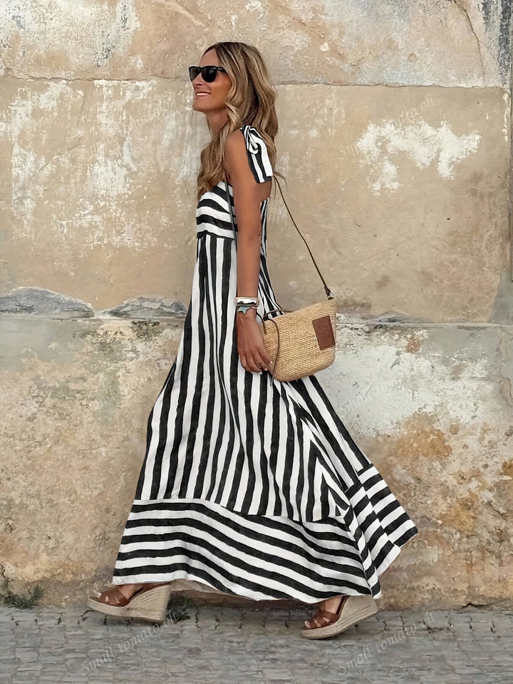 Abito maxi da donna a righe marine, design fluido e leggero. Perfetto per giornate estive in spiaggia o serate eleganti.