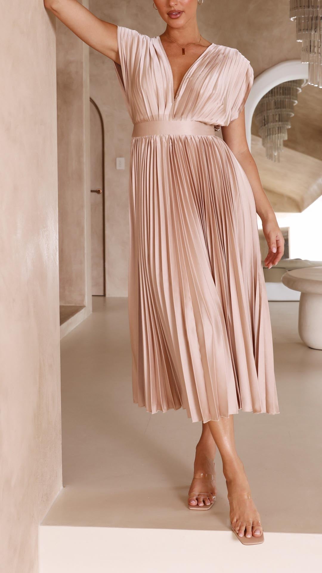 Abito da cerimonia rosa, taglio midi, plissettato, con scollo a V e vita alta drappeggiata, un classico elegante.