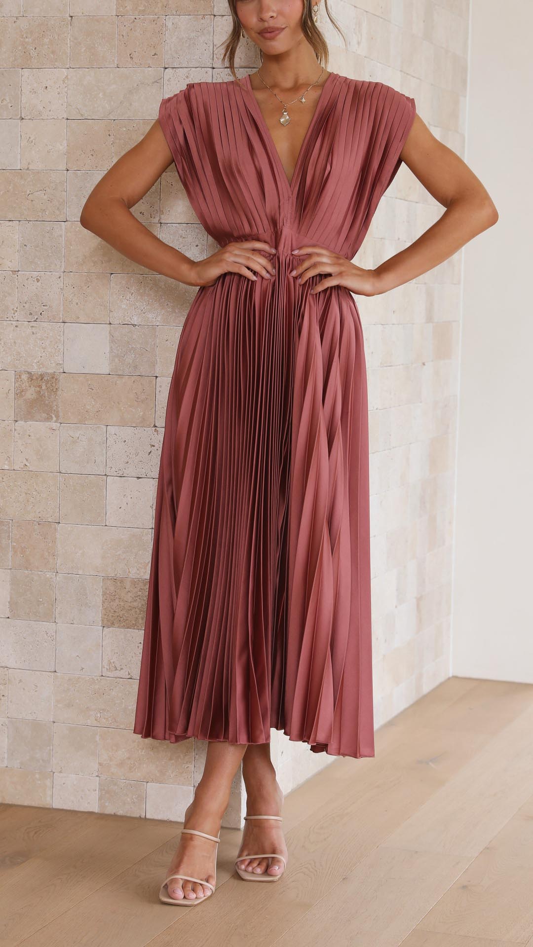 Abito donna nero plissettato con scollo a V, vita alta e drappeggio delicato, perfetto per serate speciali.