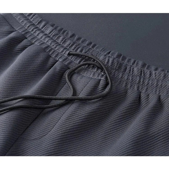 Dettaglio tessuto della tuta uomo premium, evidenziando qualità e vestibilità per un look athleisure.