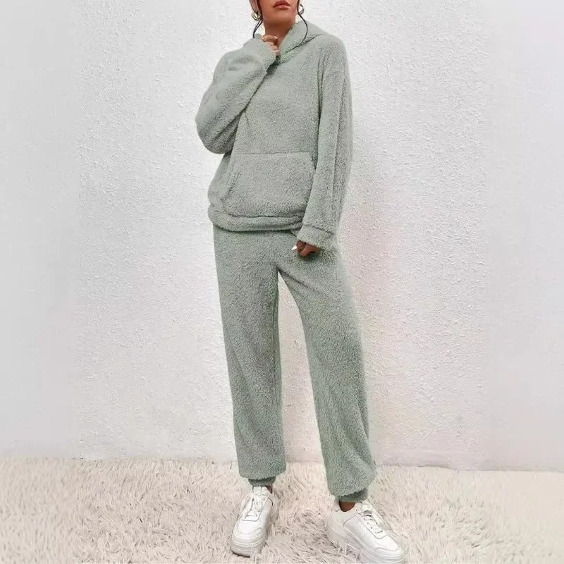 Donna indossa completo invernale, felpa e jogger, per un look rilassato e comodo in casa o all'aperto.
