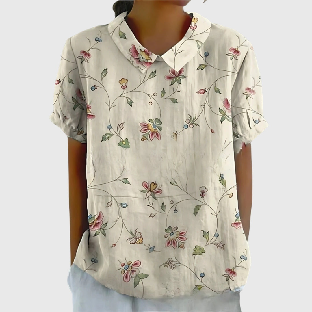 Elegante blusa floreale da donna con colletto, maniche corte e design vivace, per un outfit estivo.