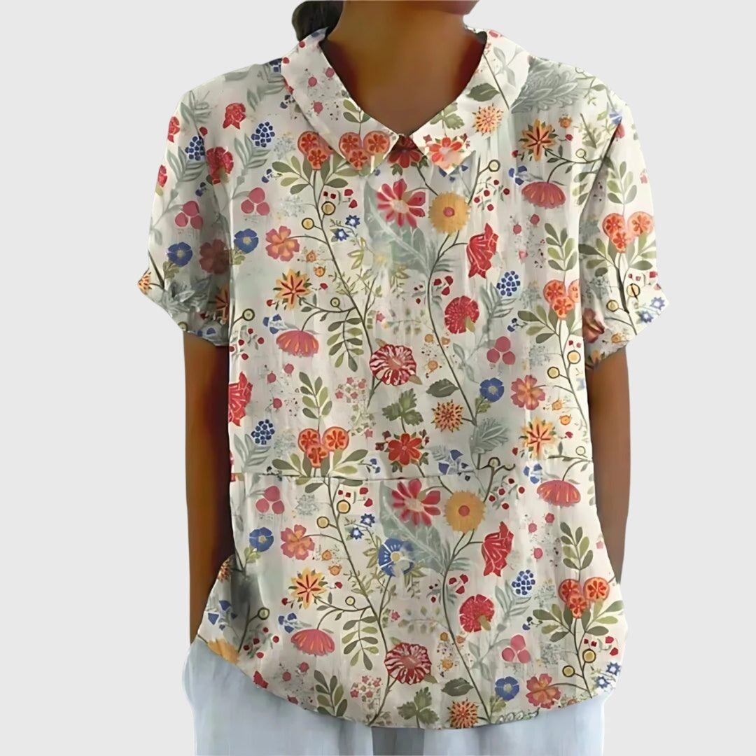 Blusa donna a fantasia floreale con colletto a punta e maniche corte, ideale per giornate estive.