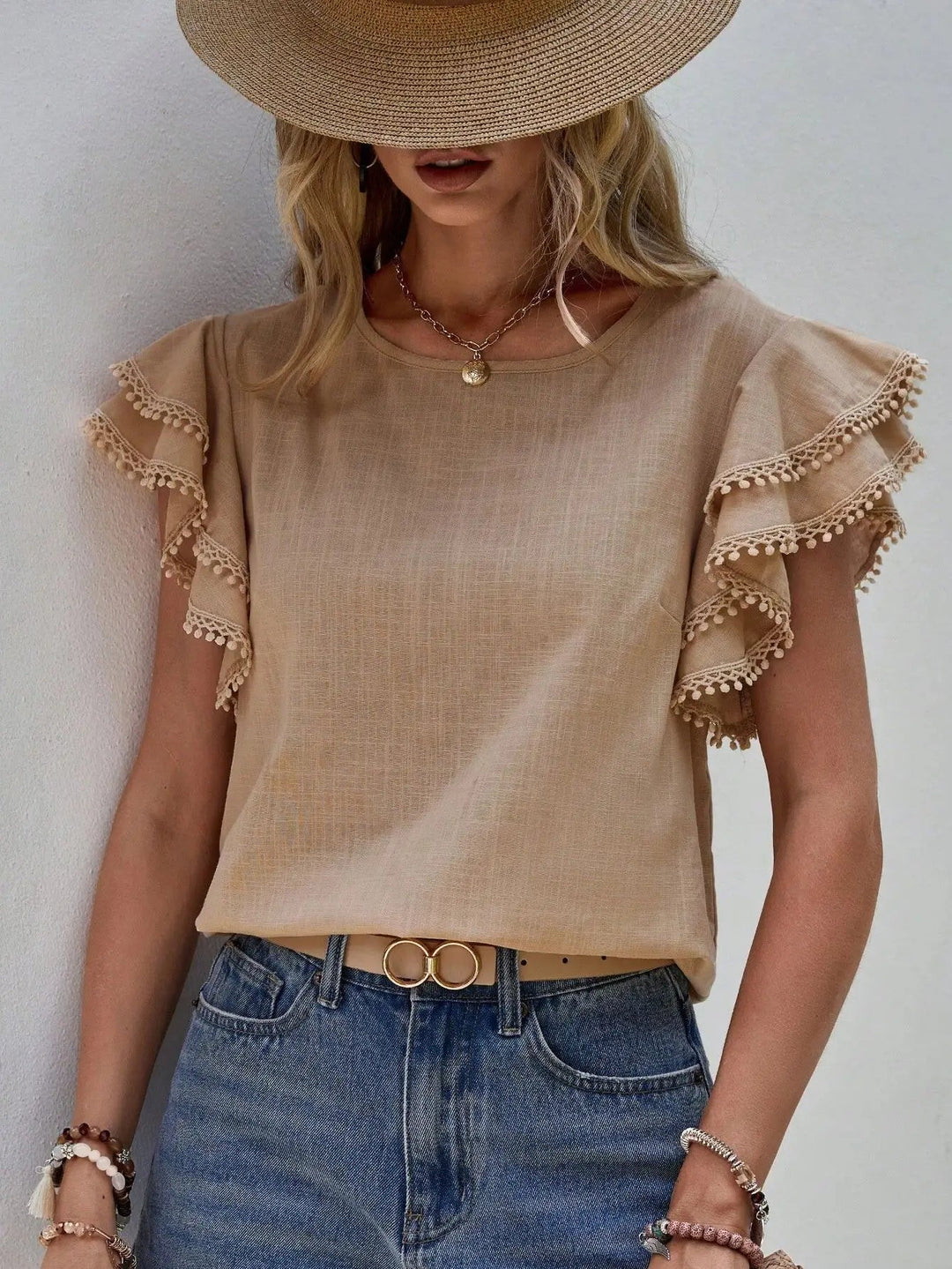 Top estivo donna con maniche a volant, dettagli romantici e pompon. Ideale per look casual primavera estate.