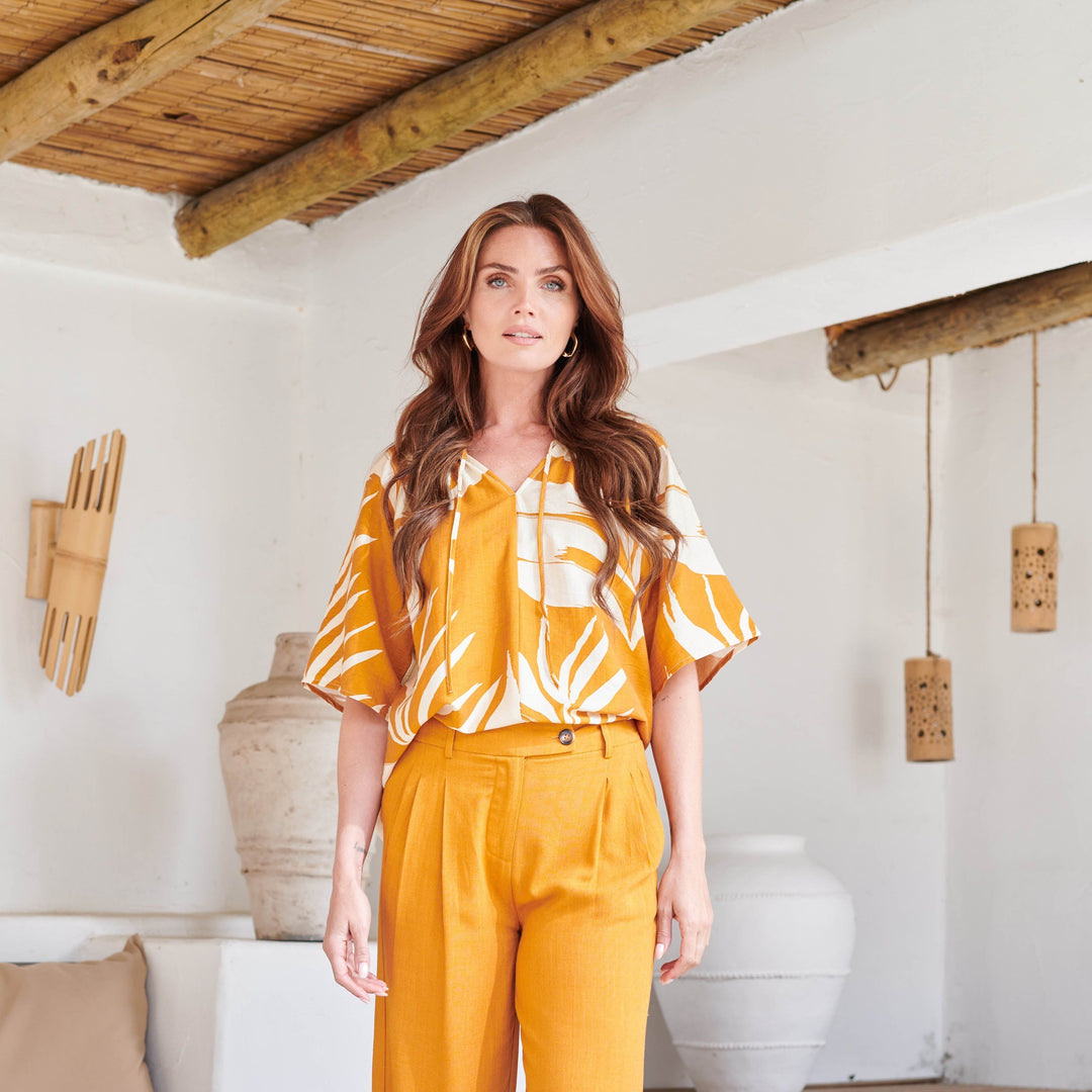 Blusa donna elegante, colore arancio intenso con raffinata stampa a foglie. Tunica estiva a maniche corte per un look distintivo.