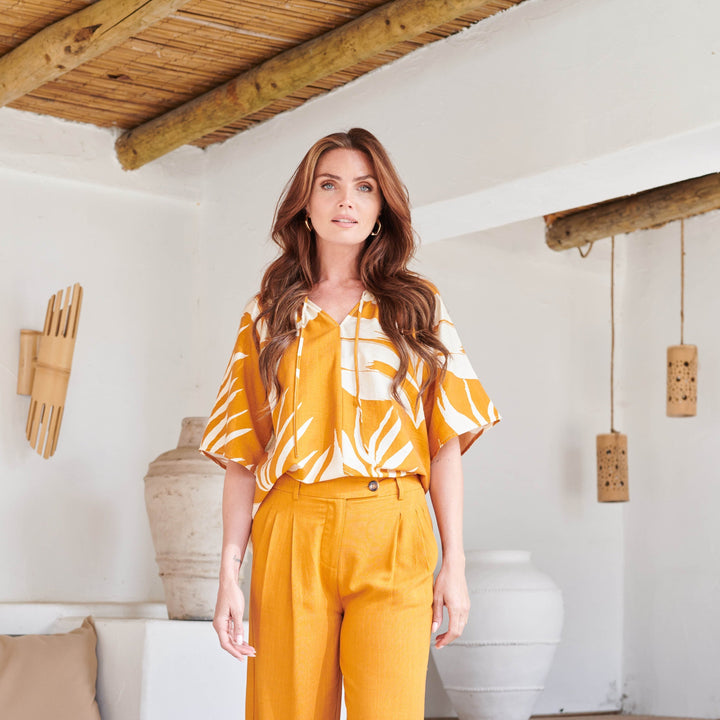 Blusa donna elegante, colore arancio intenso con raffinata stampa a foglie. Tunica estiva a maniche corte per un look distintivo.