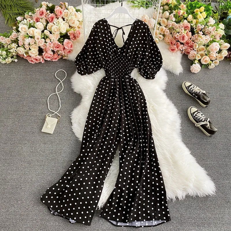 Eleganza estiva con tuta a pois da donna. Vita smock, gamba larga e maniche a palloncino. Outfit casual chic perfetto.