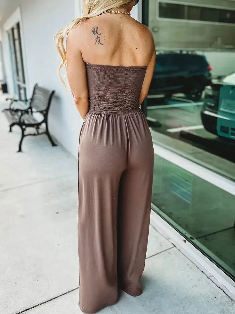 Raffinata tuta intera estiva donna con bustier arricciato e pantaloni a gamba larga. Stile primavera-estate.
