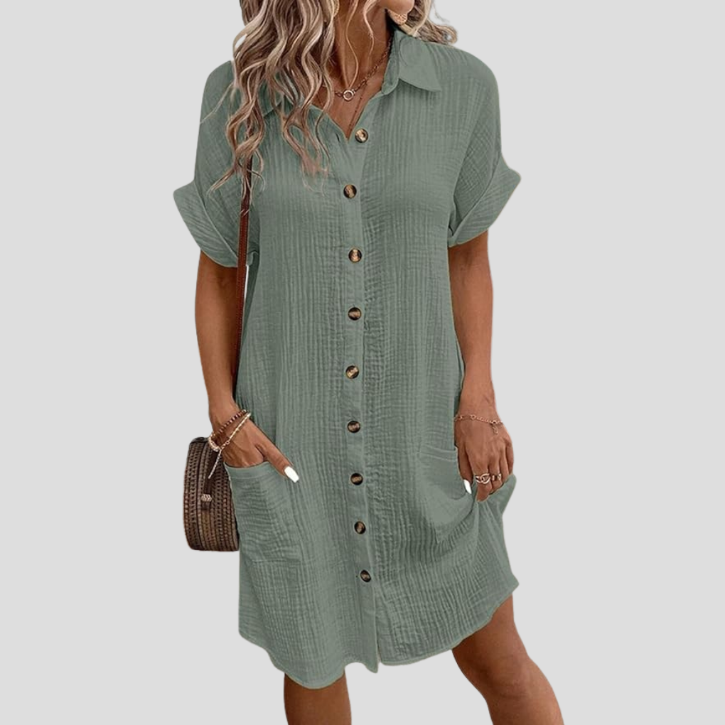 Vestito a camicia da donna con bottoni e tasche laterali, un capo essenziale per un look raffinato e comodo.