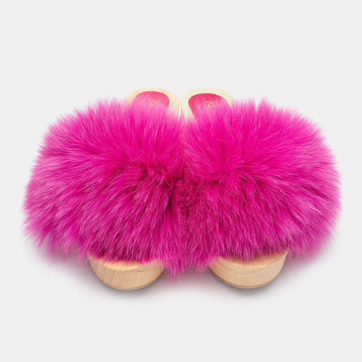 Eleganti zoccoli da donna con base in legno scuro e accattivante fascia in vera pelliccia di volpe fucsia.