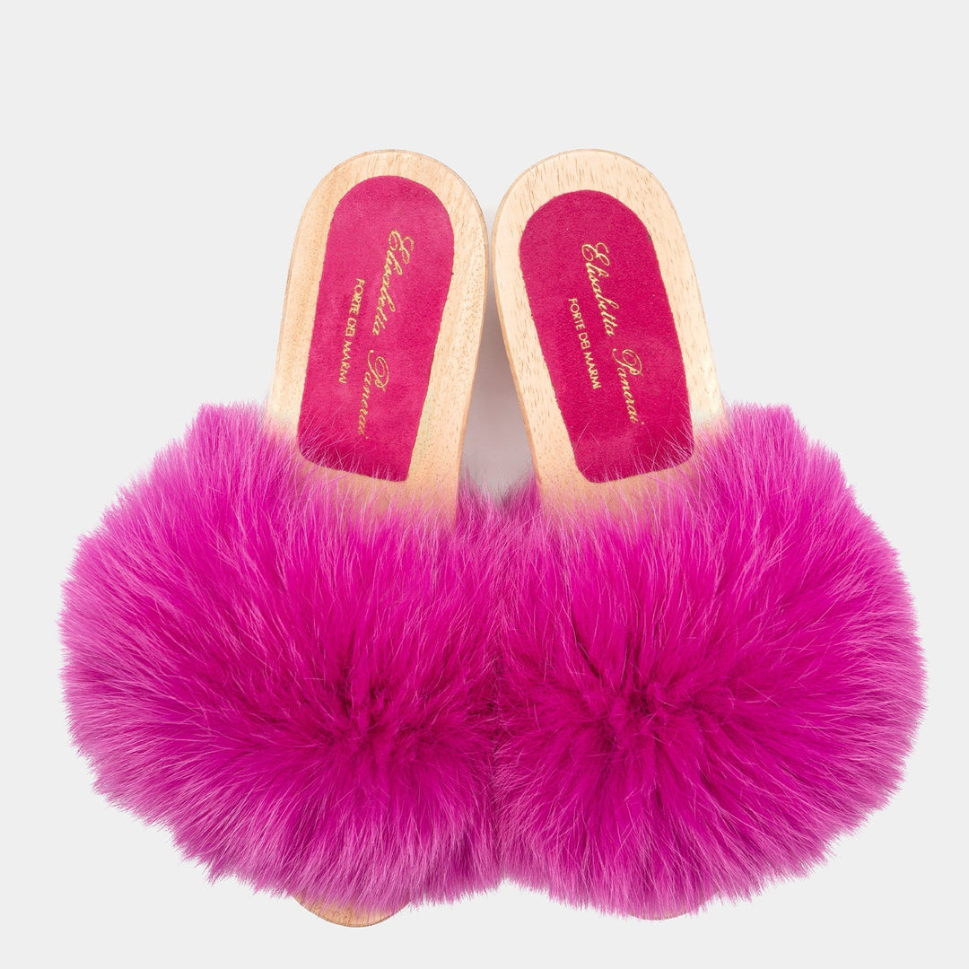 Zoccoli donna artigianali Made in Italy con suola in legno e raffinata fascia in pelliccia di volpe fucsia.