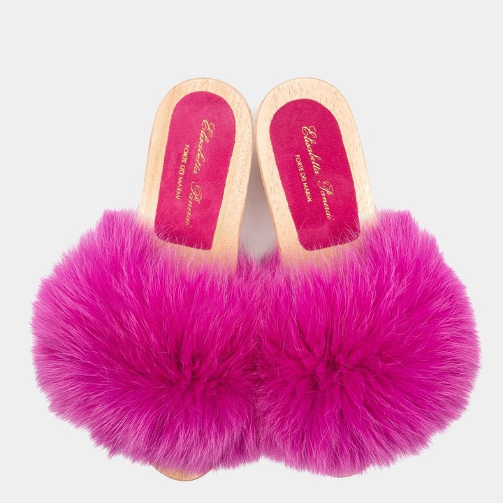 Zoccoli donna artigianali Made in Italy con suola in legno e raffinata fascia in pelliccia di volpe fucsia.