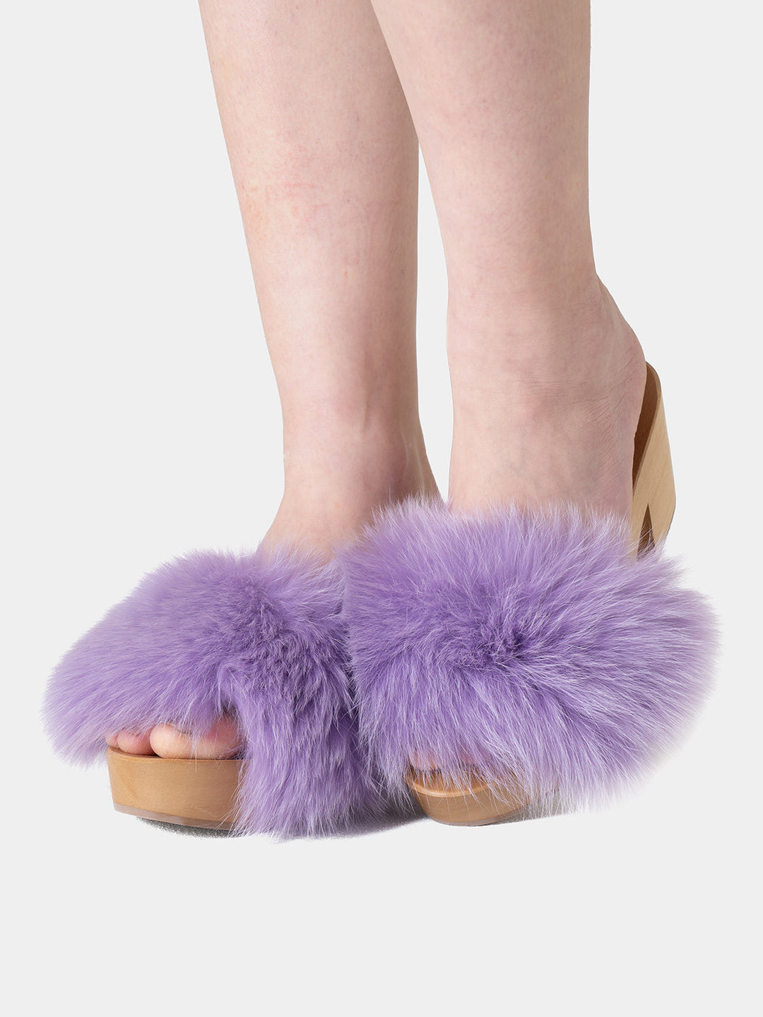 Elegante zoccolo estivo da donna in legno e morbida volpe lilla, simbolo di lusso e moda italiana.
