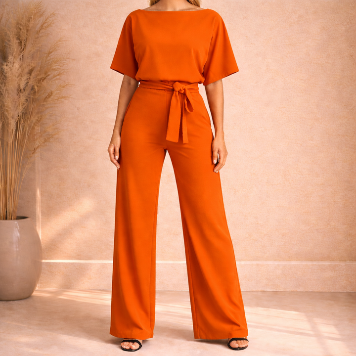 Outfit tuta donna elegante nera con fiocco raffinato e gamba larga, ideale per eventi serali chic e cerimonie.