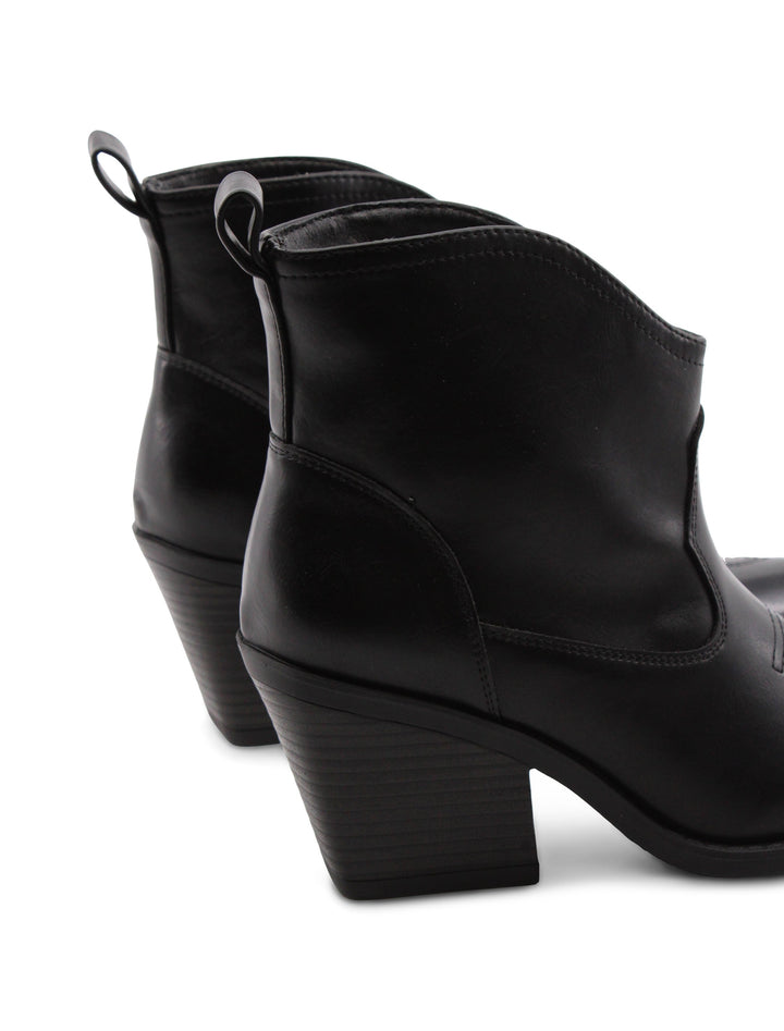 Primo piano sugli stivaletti texani neri donna con punta affusolata e tacco 7,5 cm, dettaglio moda.