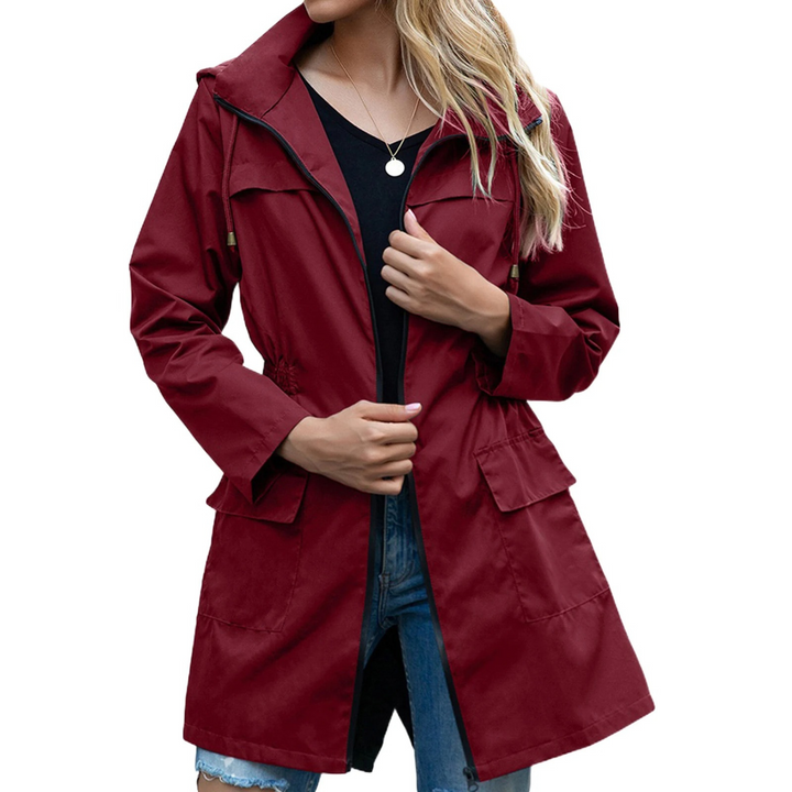 Donna con giacca impermeabile leggera, cammina all'aperto. Protezione versatile per ogni avventura.