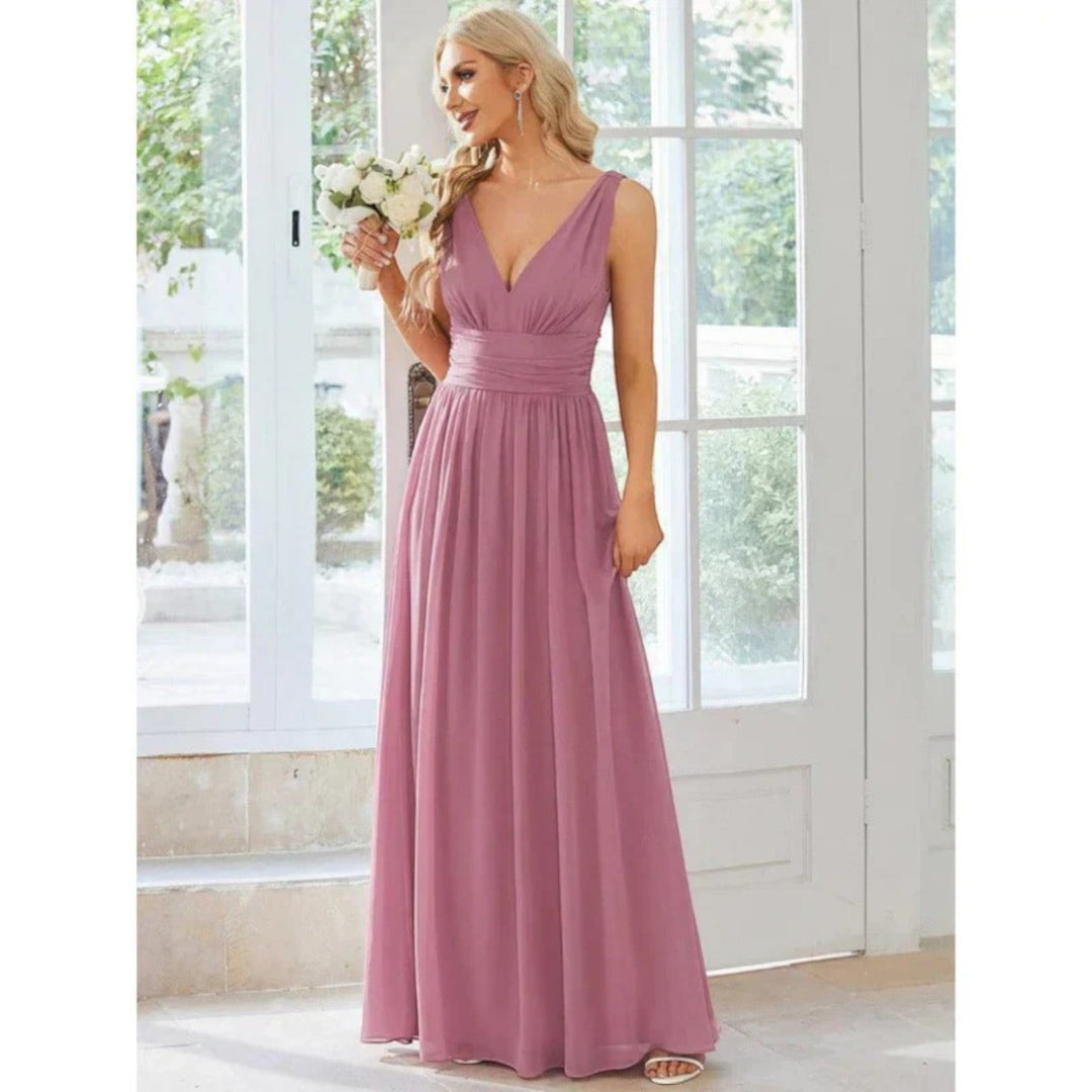 Donna in abito maxi elegante scollo a V, pronta per una festa estiva o un evento serale.