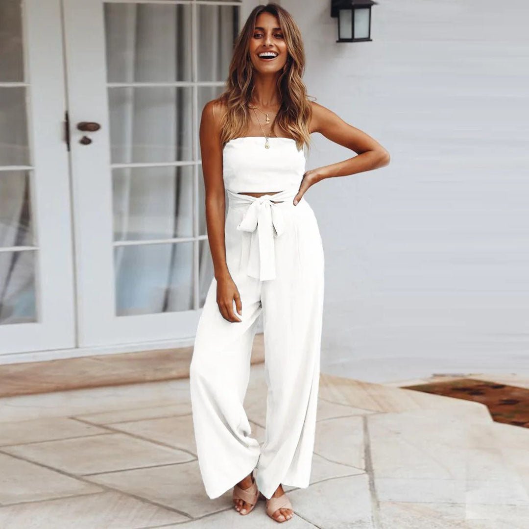 Tuta donna alla moda in tessuto leggero, bustier e gamba larga. Nodo in vita per un tocco estivo.