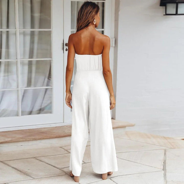 Tuta intera elegante donna con top bustier e pantalone a gamba larga. Dettaglio nodo in vita alla moda.