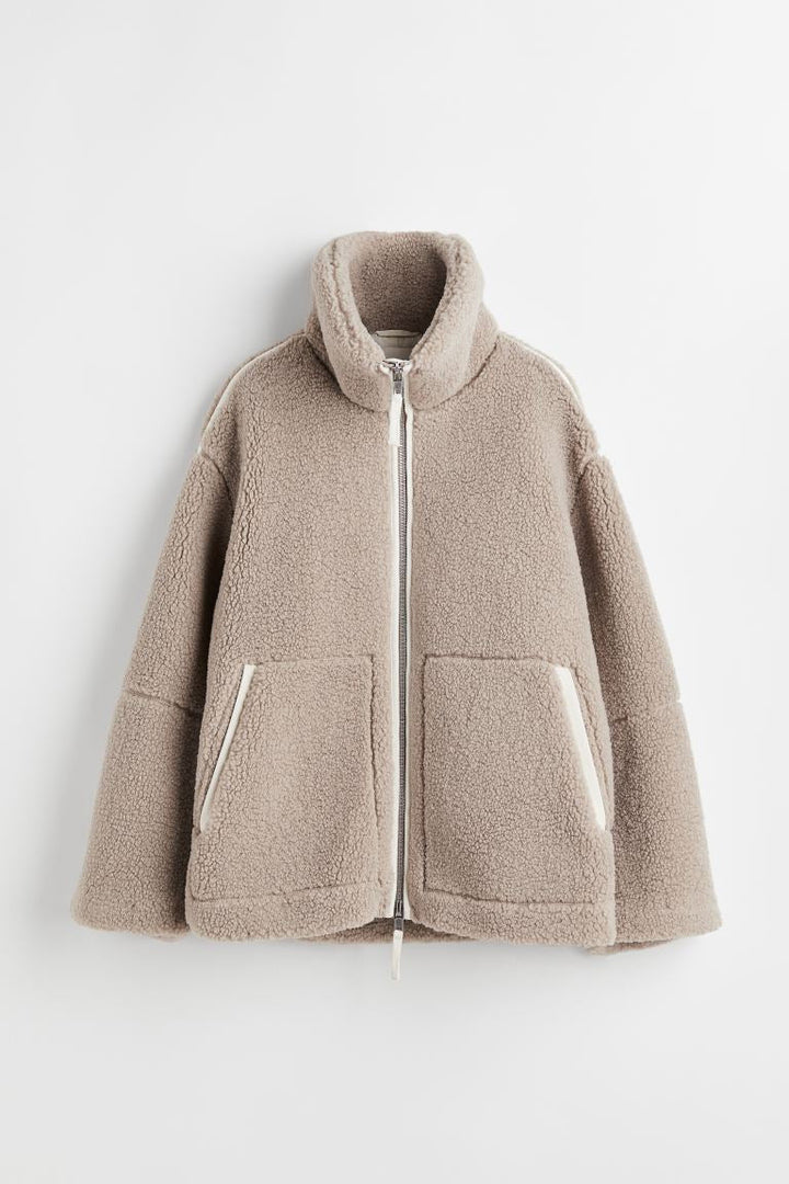 Giacca da donna in borg sintetico beige, con collo alto e doppia zip, per un look invernale elegante.