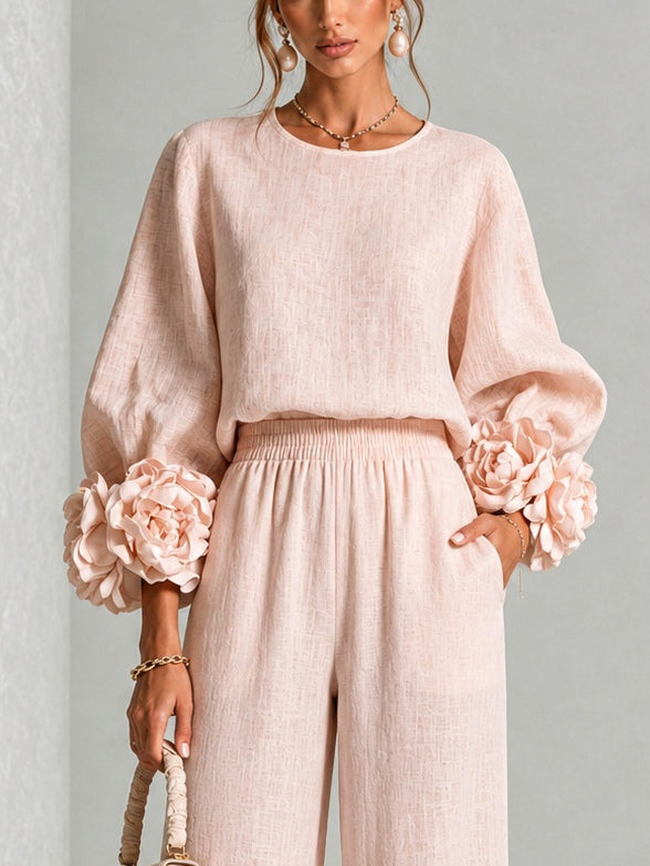Completo donna in lino floreale, due pezzi: top a maniche e pantaloni larghi vita alta. Stile elegante e confortevole.
