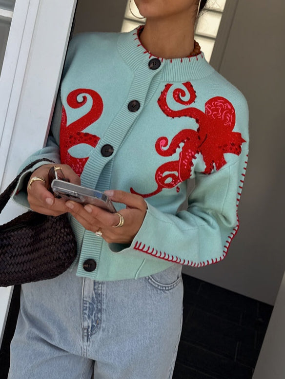Cardigan donna azzurro e morbido con motivo polpo, perfetto per un abbigliamento quotidiano confortevole e di stile.