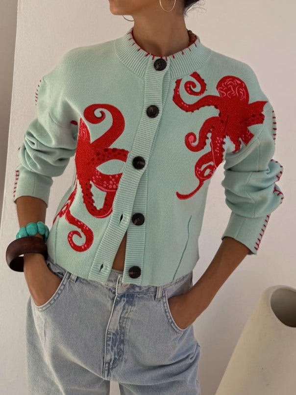 Cardigan donna azzurro morbido con originale motivo polpo, ideale per stile casual e moda femminile.