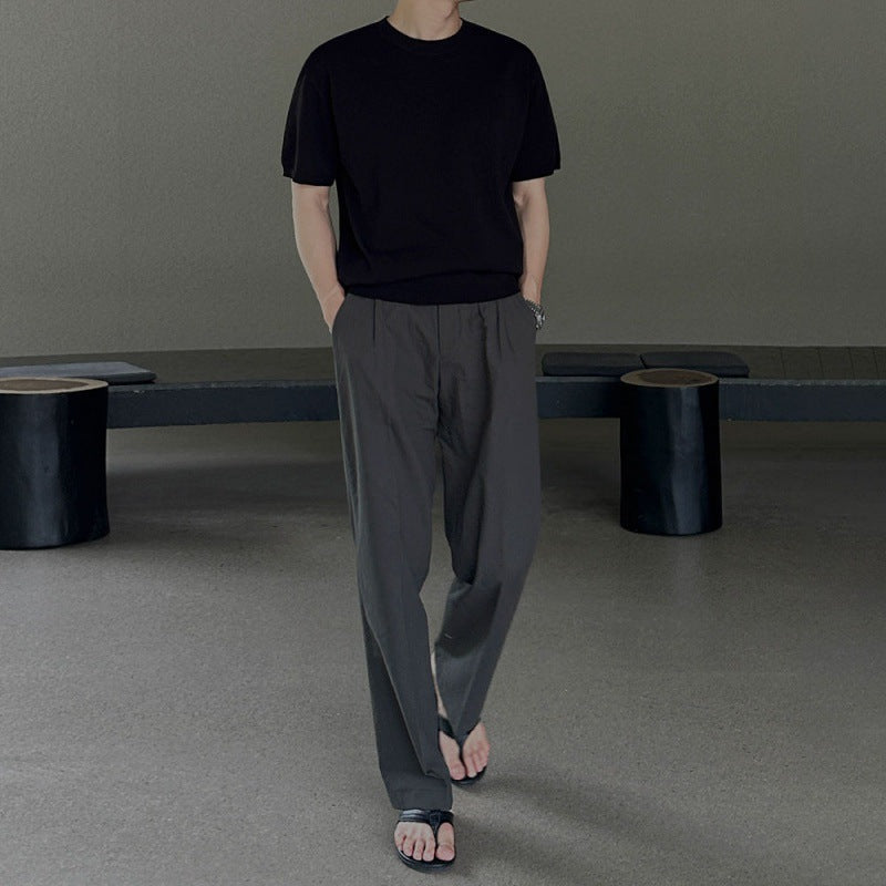 Uomo indossa pantaloni casual grigi a gamba dritta, perfetti per look streetwear moderno e confortevole.