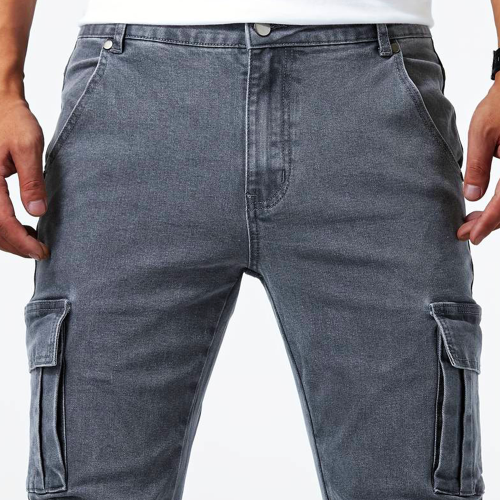 Uomo indossa jeans cargo slim fit blu, pantaloni multitasche per un outfit urbano e trendy.
