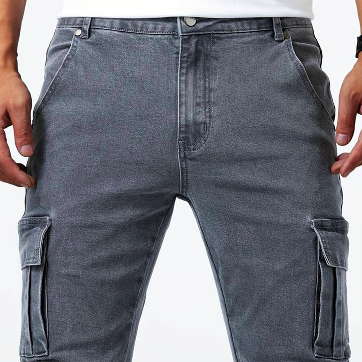 Uomo indossa jeans cargo slim fit blu, pantaloni multitasche per un outfit urbano e trendy.