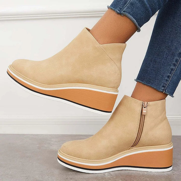 Primo piano stivali donna in suede beige, texture morbida e dettagli di lusso. Calzature invernali.