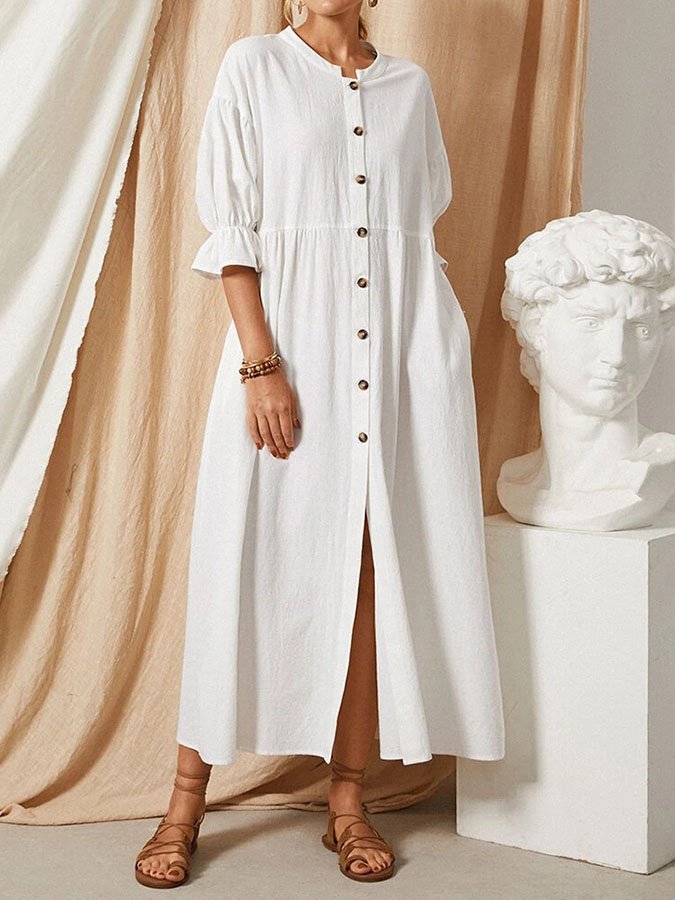 Abito donna lungo bianco estivo, caratterizzato da abbottonatura e maniche a palloncino per un tocco chic e casual.