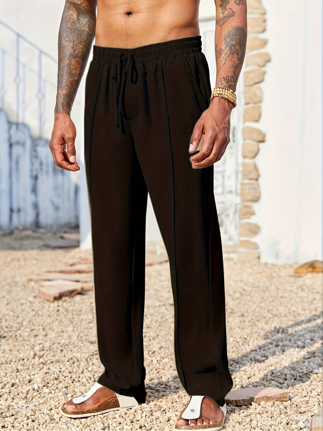 Uomo indossa pantaloni straight fit alla caviglia, look casual elegante ideale per streetwear e relax.