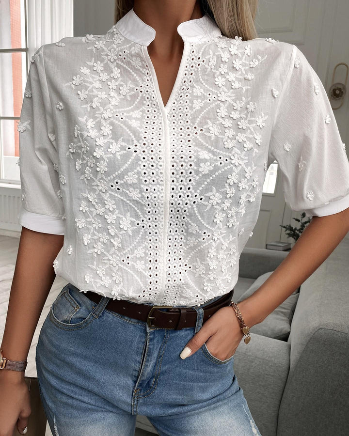 Blusa donna bianca elegante con scollo a V e dettagli in pizzo, ideale per ufficio o look casual estivo.