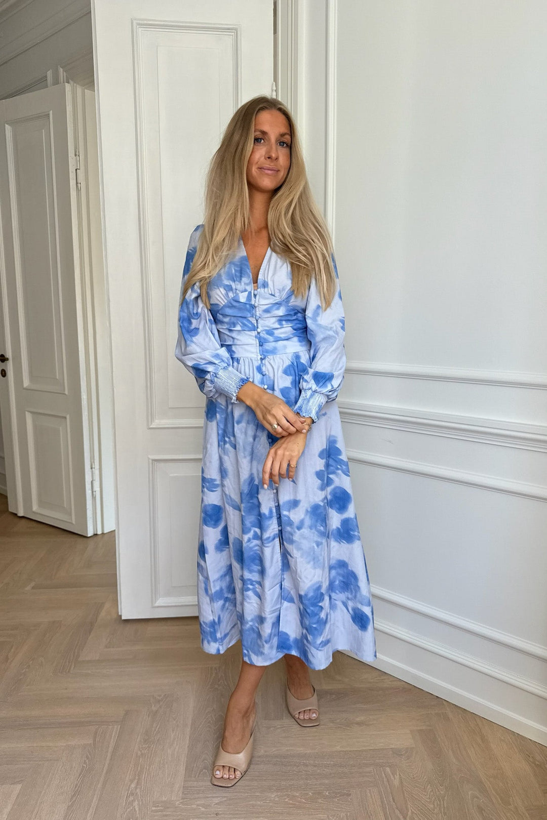 Abito midi donna blu a fiori con eleganti bottoni frontali e maniche lunghe, stile sofisticato e moderno.