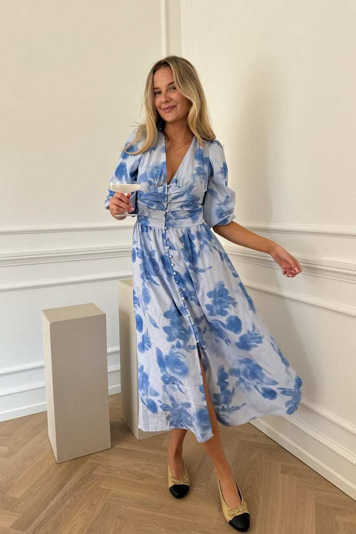 Abito donna midi blu con stampa floreale, maniche lunghe e bottoni decorativi. Stile elegante e confortevole.