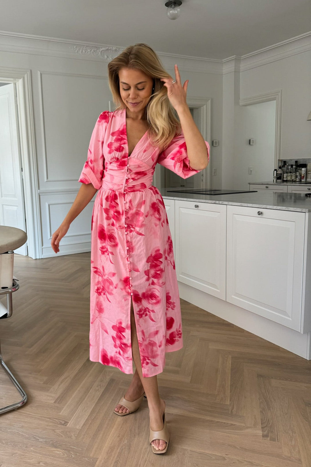 Abito floreale rosa midi da donna con bottoni frontali, un capo versatile e comodo per ogni occasione.