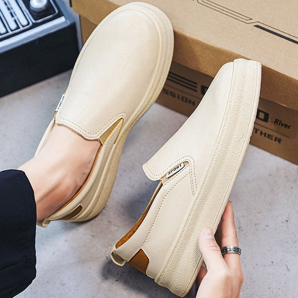 Uomo indossa scarpe da ginnastica bianche e beige, ideali per passeggio e uso quotidiano, offrono stabilità.