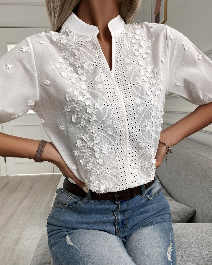 Blusa bianca da donna con pizzo sullo scollo a V e maniche corte, ideale per un look elegante e confortevole.