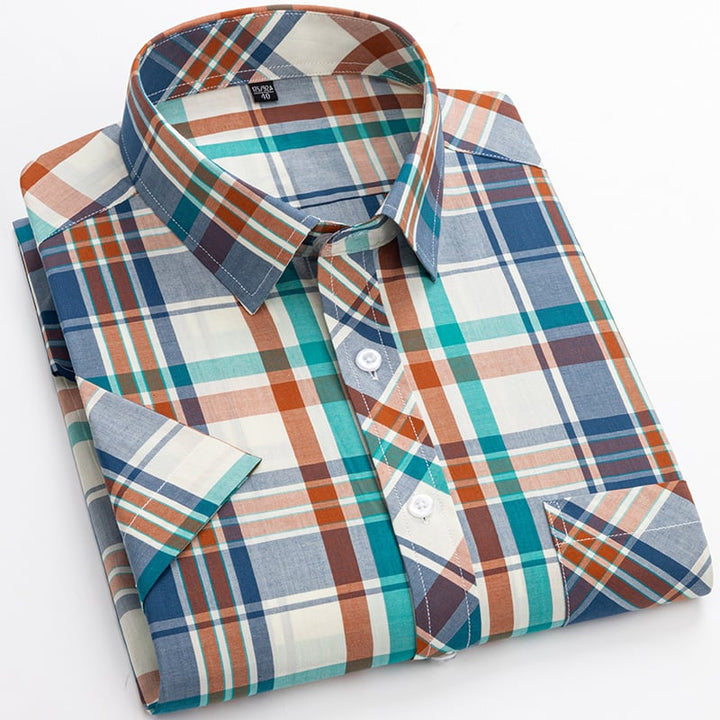 Uomo cammina con camicia scozzese maniche corte. Outfit dinamico e casual per la moda uomo estiva.