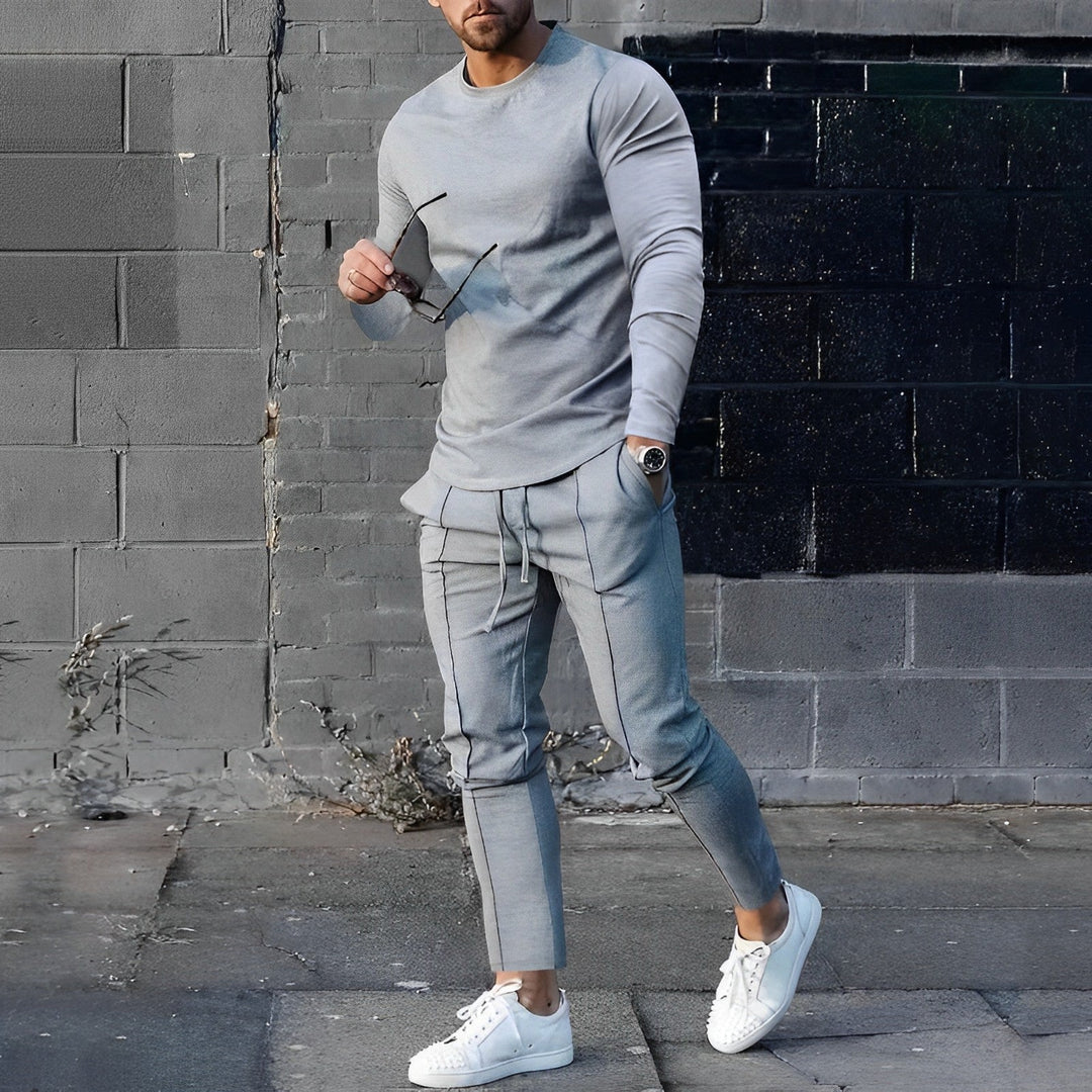 Completo uomo moderno, maglione e pantaloni slim fit. Outfit maschile elegante, vestibilità contemporanea.