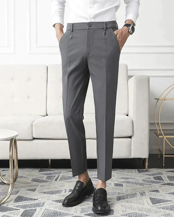 Moda uomo: pantaloni slim fit beige con pieghe, gamba affusolata. Stile elegante, formale o casual chic per l'ufficio.
