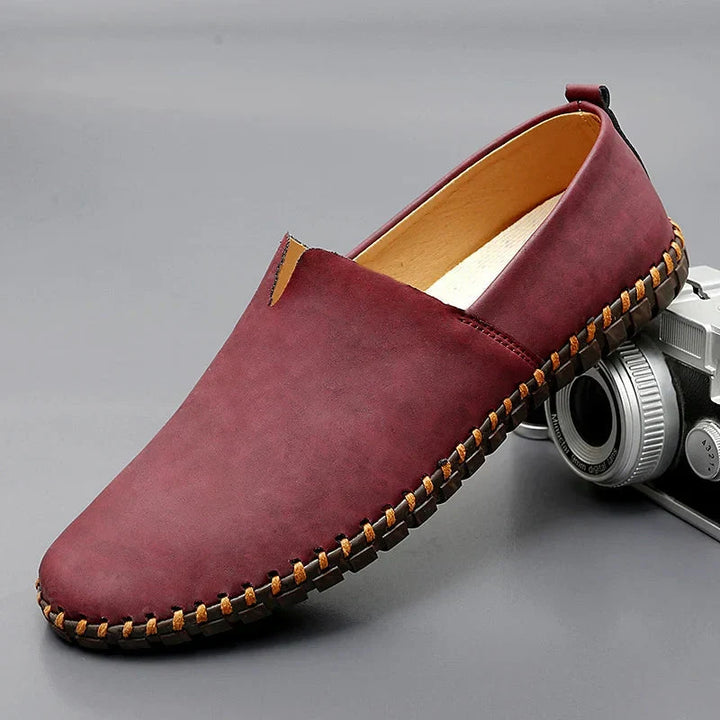 Eleganti mocassini uomo in pelle blu, design slip-on classico e suola cucita artigianale.