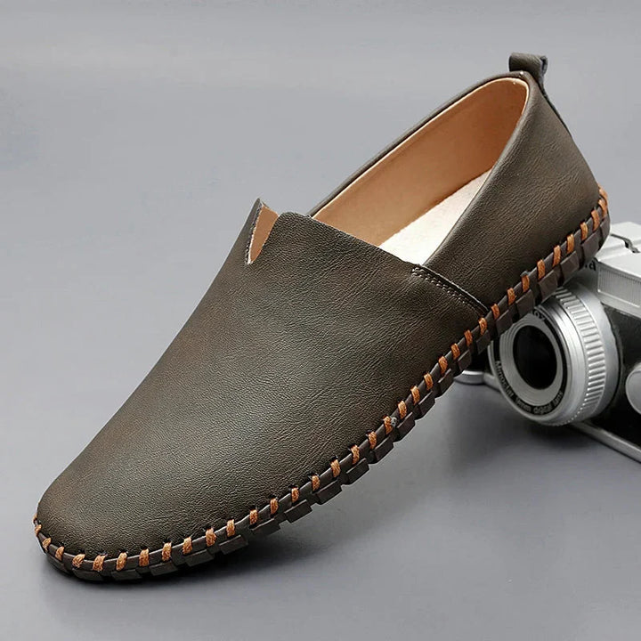 Calzature uomo: mocassini neri slip-on, stile classico e suola cucita per un look sofisticato.
