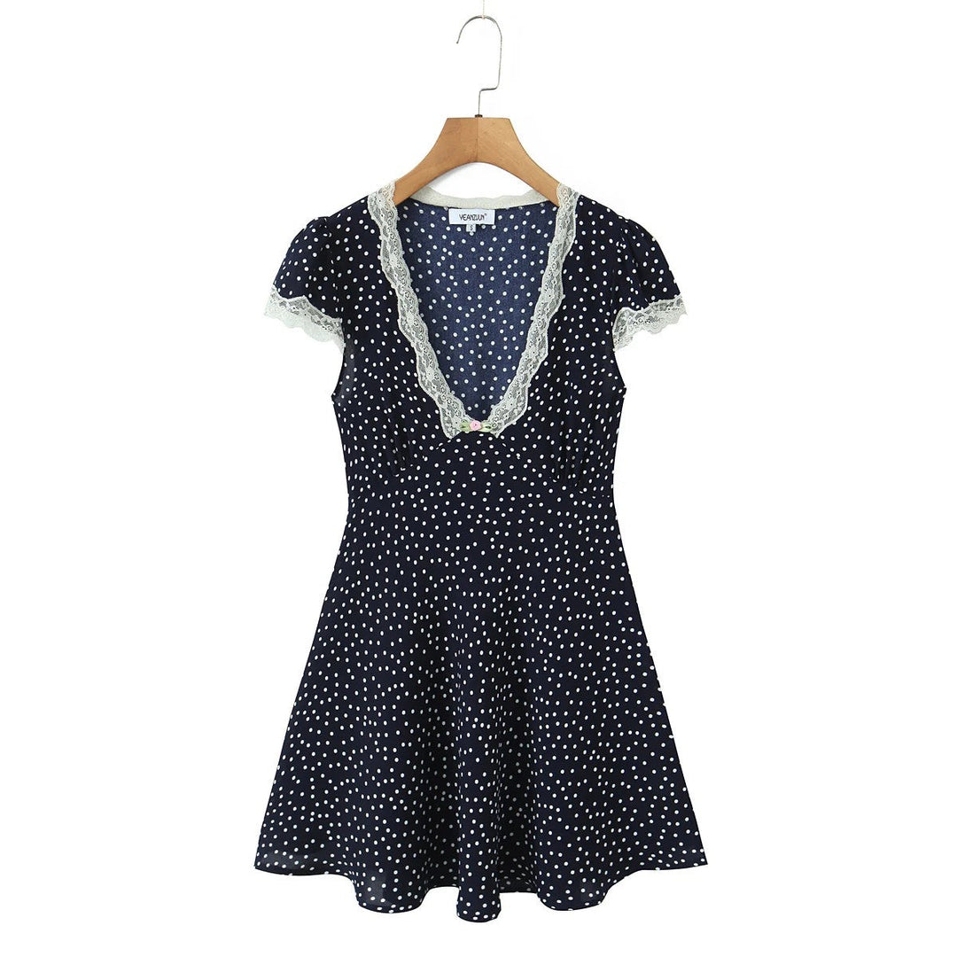 Abito midi donna a pois con scollo a V e cintura in vita. Maniche a sbuffo, look elegante e classico primavera.